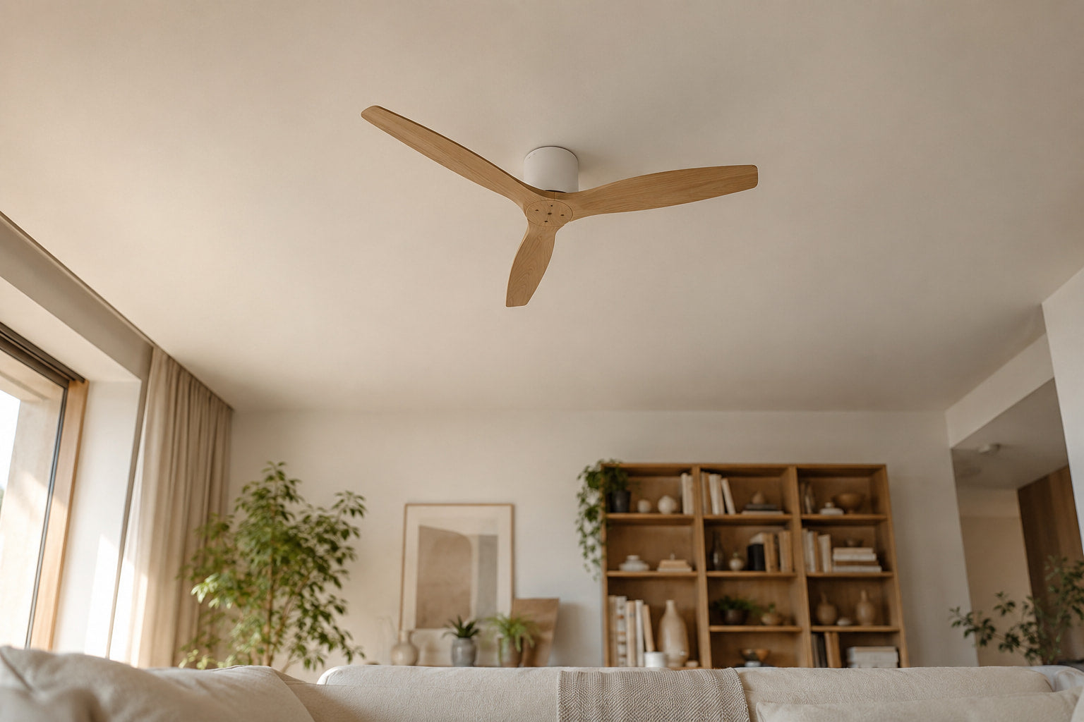 Ventilateur de plafond en bois clair installé au plafond d'un salon lumineux